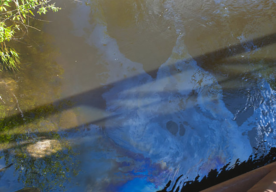 Oil can be seen on the surface of the Grand River in Lions Park in Jackson near an oil boom on Thursday , May 22, 2014.. Hundreds of gallons have spilled into the river. The EPA, DEQ and city officials are on scene supervising the cleanup. (J. Scott Park - MLive.com)